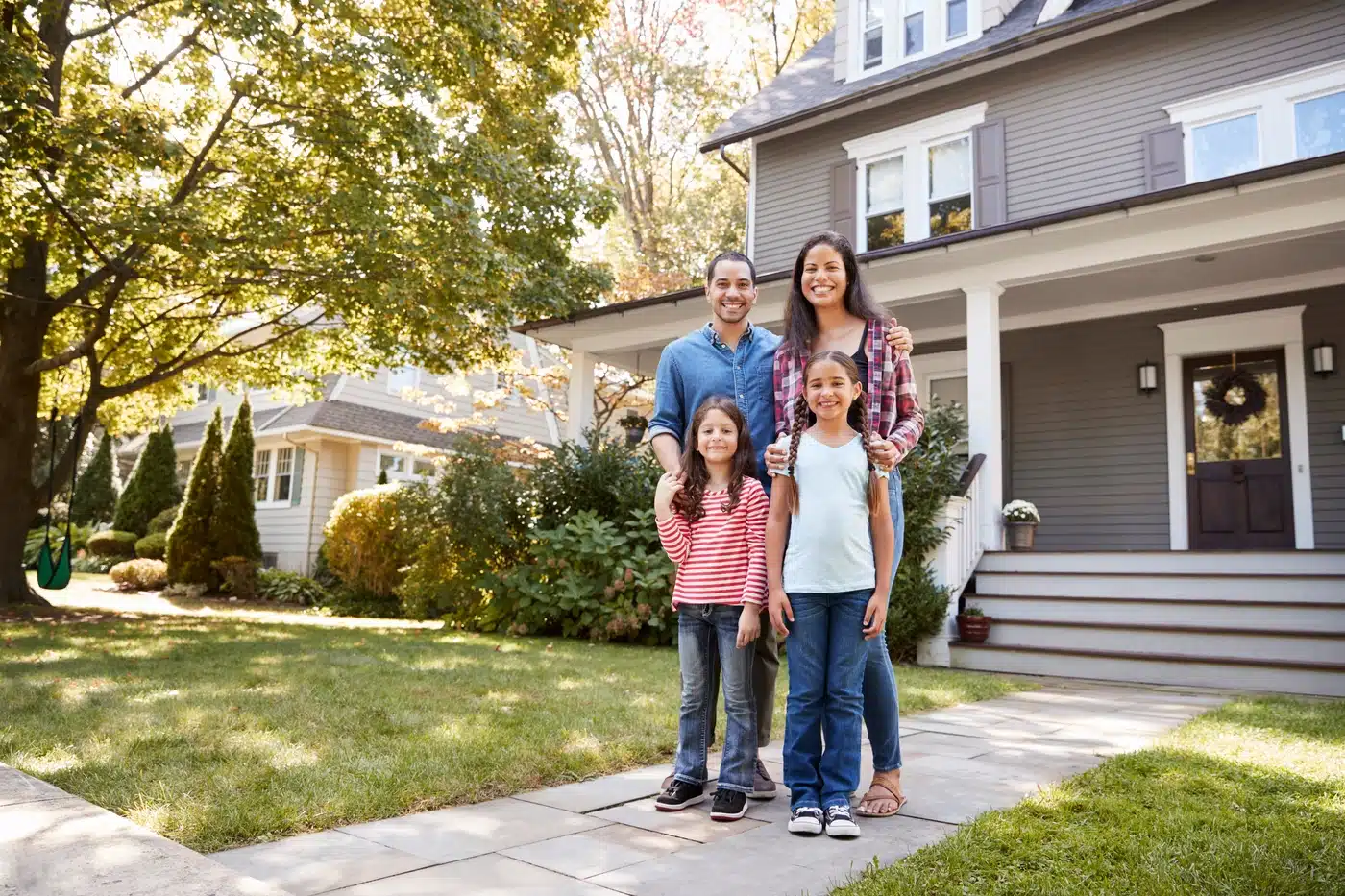 A happy Georgia family in front of their home protected by a Whitt's roof