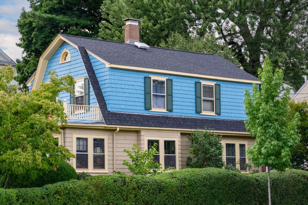 blue and yellow house with gambrel roof