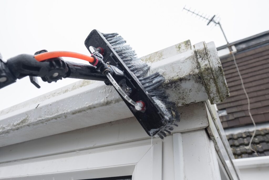 A brush cleaning dirty roof and gutters