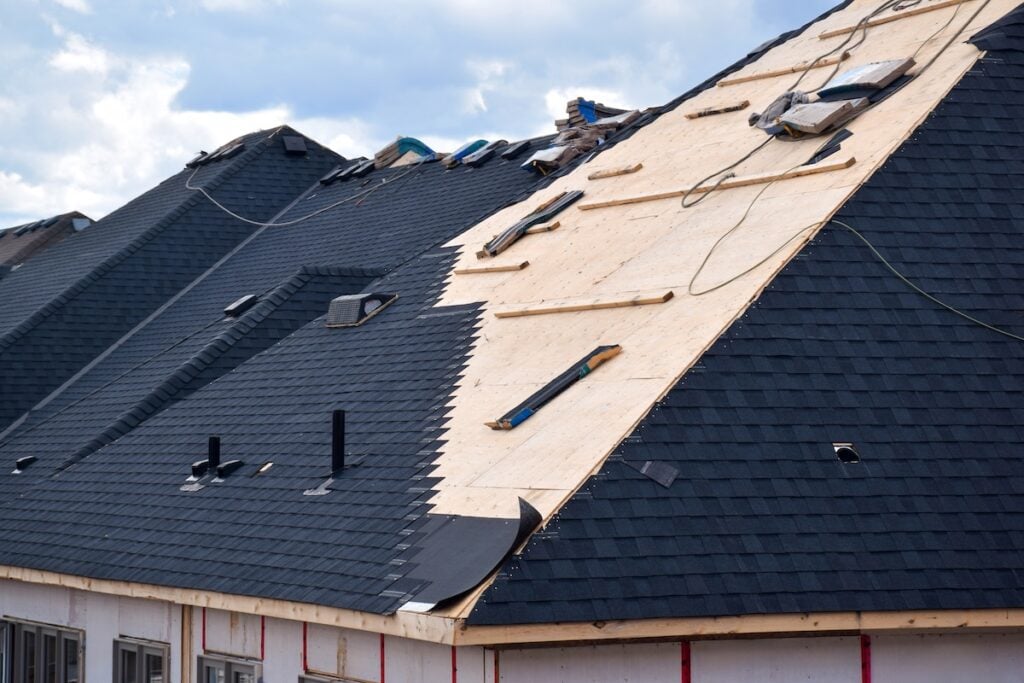 Closeup installation of black roof shingles on a residential home
