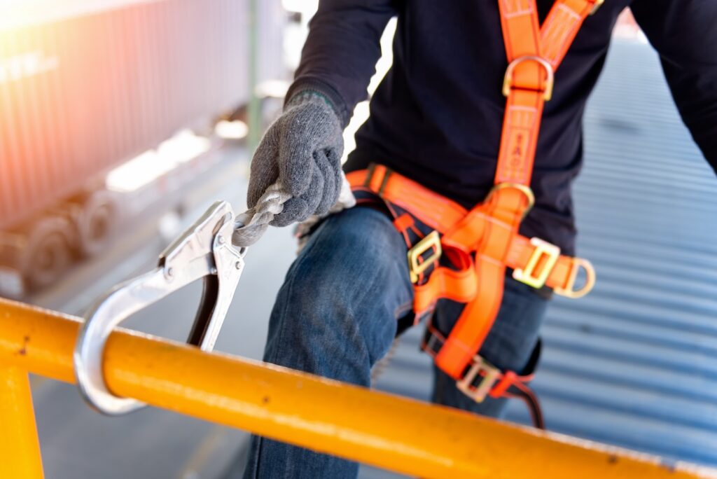 Construction worker use safety harness and safety line working on a new construction site project.Harness is a equipment for safety in construction site.