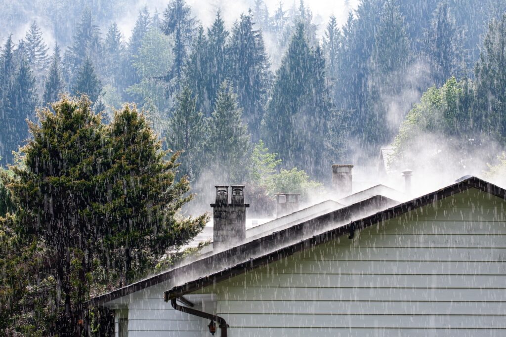 steam comes from the roof houses when the rain falls with sunny light